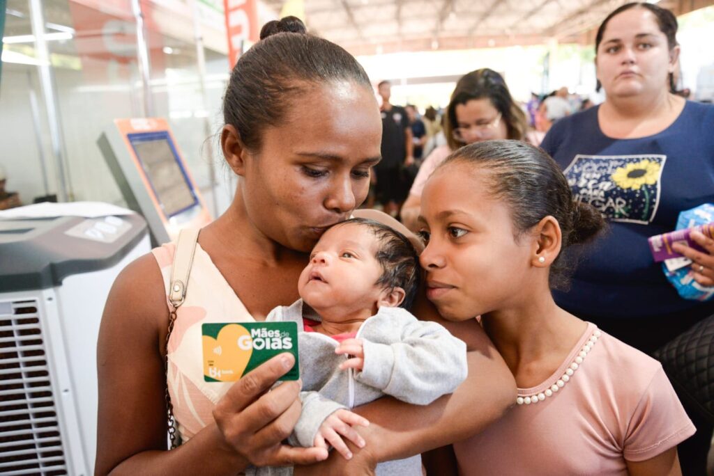 Mulher recebe cartão Mães de Goiás, benefício do Goiás Social
