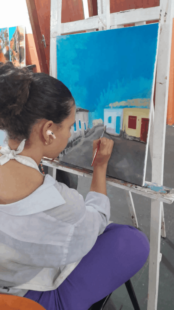 Aluna de curso de Artes Visuais do Basileu França pintando tela