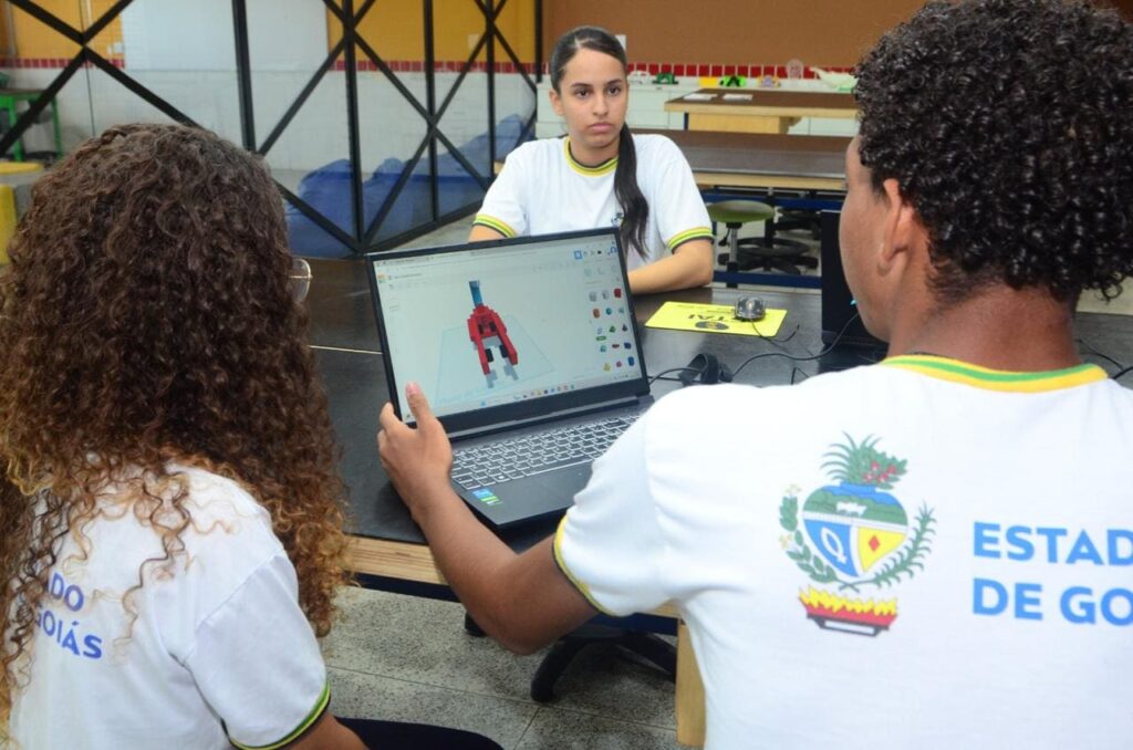 Alunos da Escola do Futuro em frente a um notebook