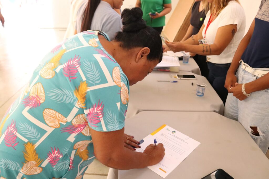 mulher assina escritura do programa casas a custo zero_Agehab