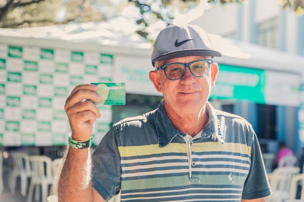 idoso com o cartão do programa Dignidade