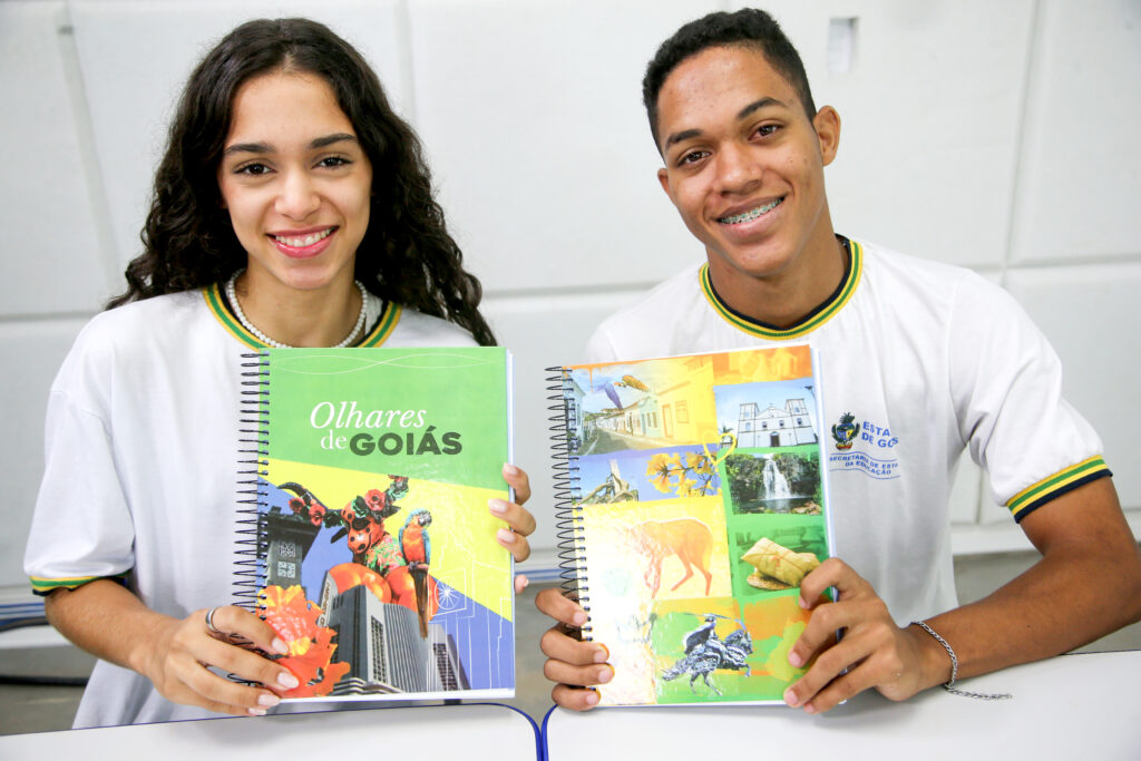 Alunos com cadernos que têm capa com desenhos que venceram concurso