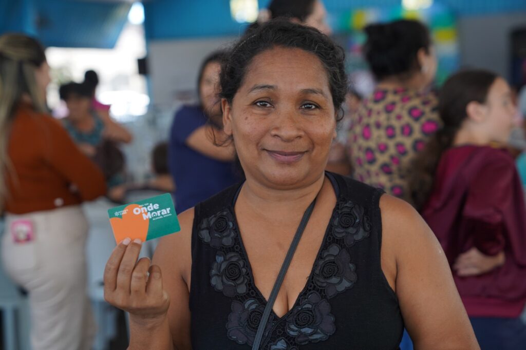 Mulher recebe cartão do Aluguel Social em Piracanjuba