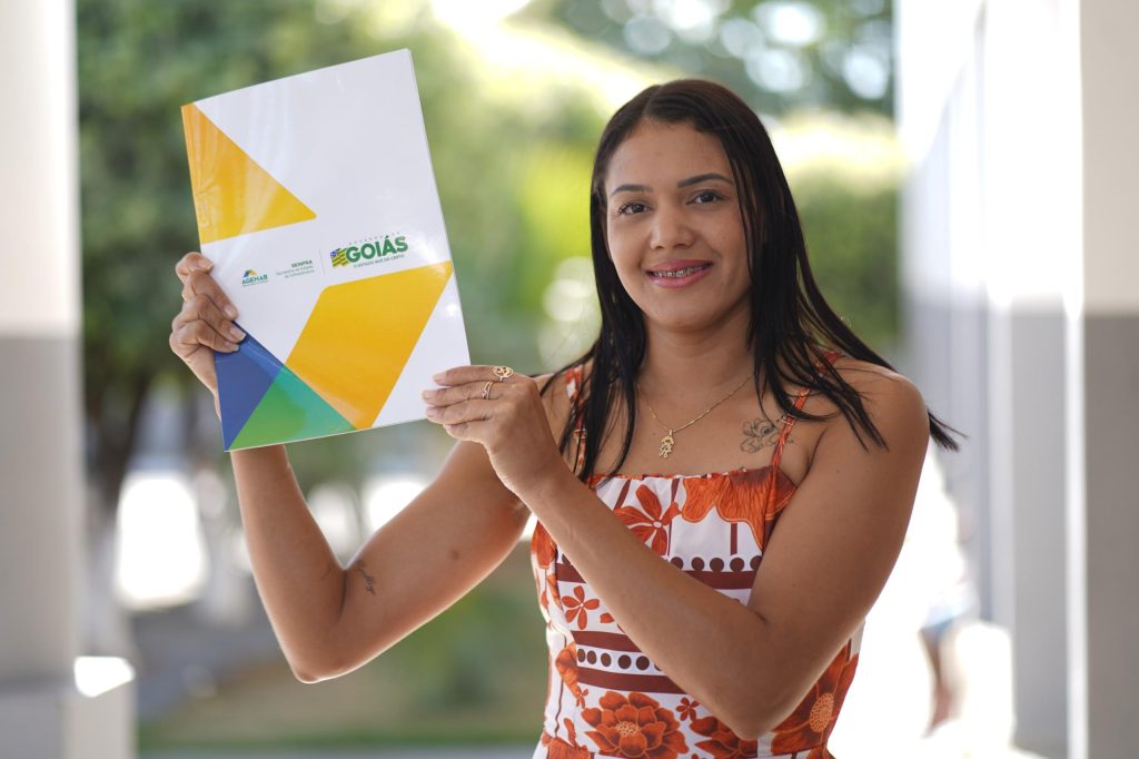 Mulher recebe escritura da Agehab