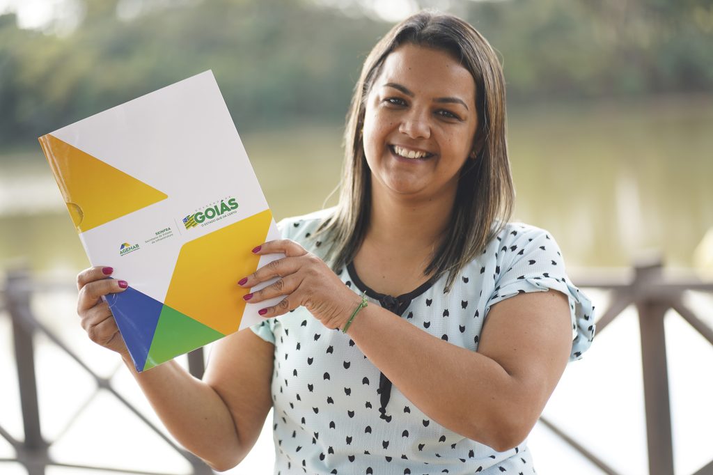 mulher com escritura do imóvel nas mãos