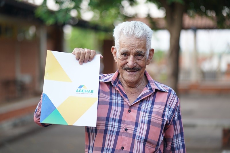 Morador segurando escritura entregue pela Agehab