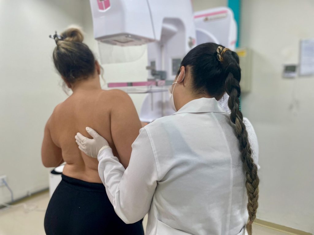 Campanha Portas Abertas do Governo de Goiás faz mais de mil mamografias em 5 dias - Mulher, auxiliada por profissional de saúde, durante realização de mamografia