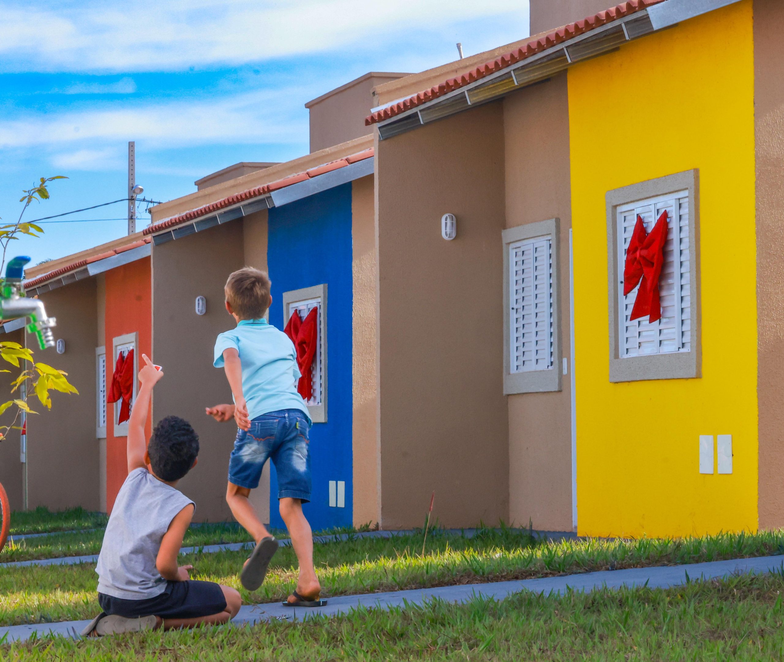 Casas a custo zero são entregues a famílias do Centro-Oeste goiano - Crianças brincando à frente das casas