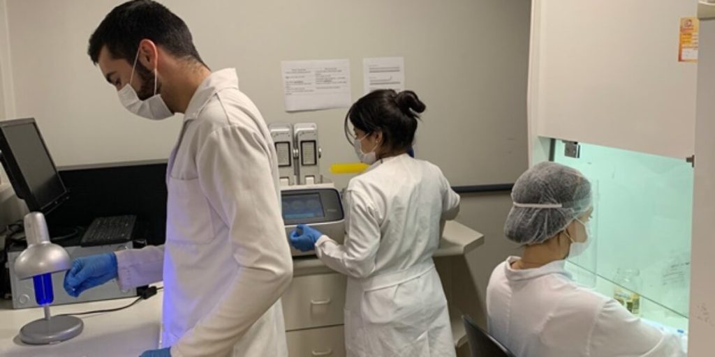 Fapeg divulga resultado final de bolsas de excelência para doutorandos em Goiás - Pesquisdores de branco trabalhando dentro de laboratório