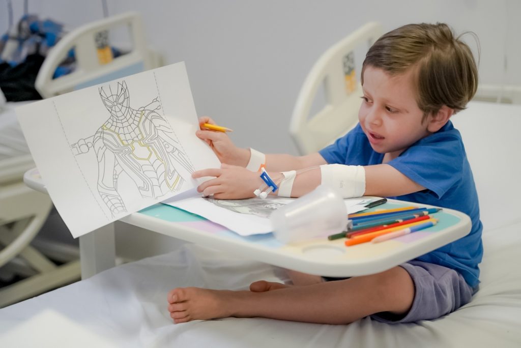 Saúde orienta sobre prevenção de acidentes domésticos durante as férias escolares, garotinho branco, de aproximadamente 4 anos, hospitalizado, desenhando