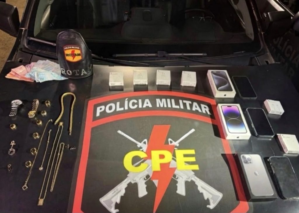 Polícia Militar prende suspeitos de furto a joalheria com apoio de inteligência artificial em Goiânia - joias e celulares expostos sobre capô de viatura da CPE