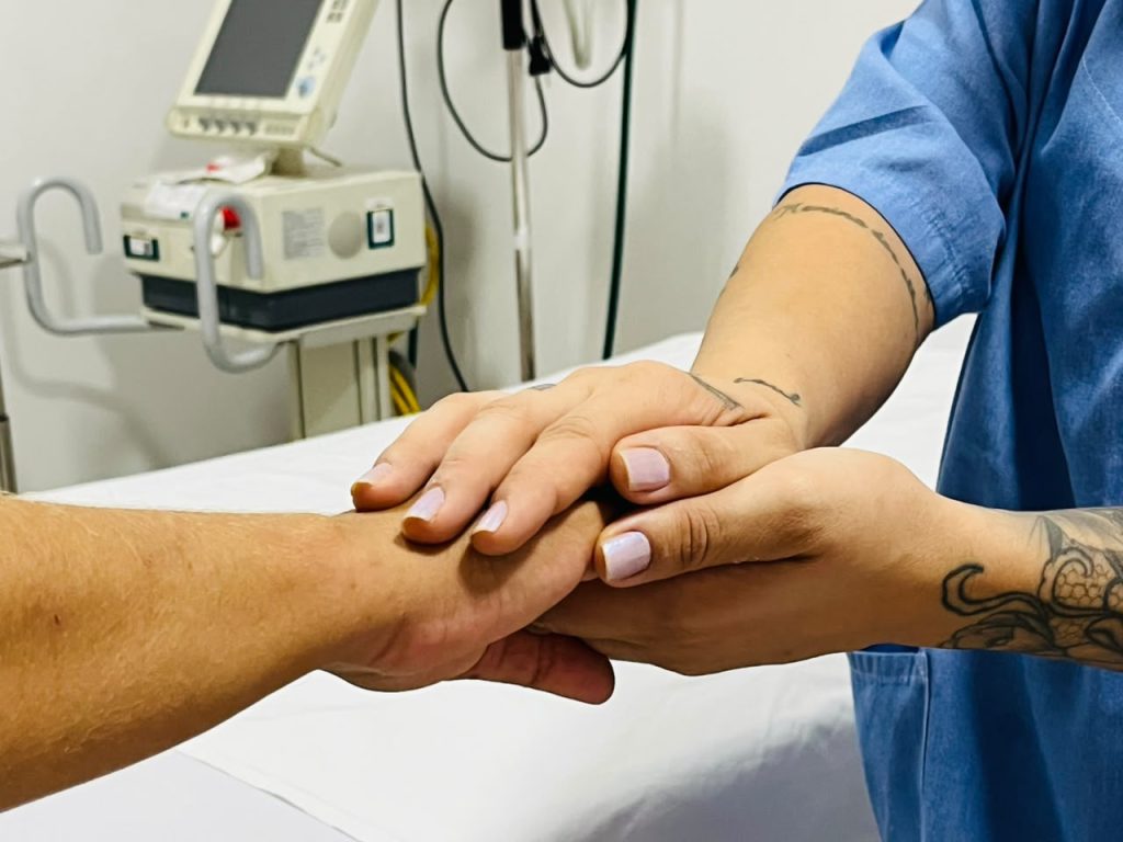 mãe de enfermeira segurando mãe de paciente idoso